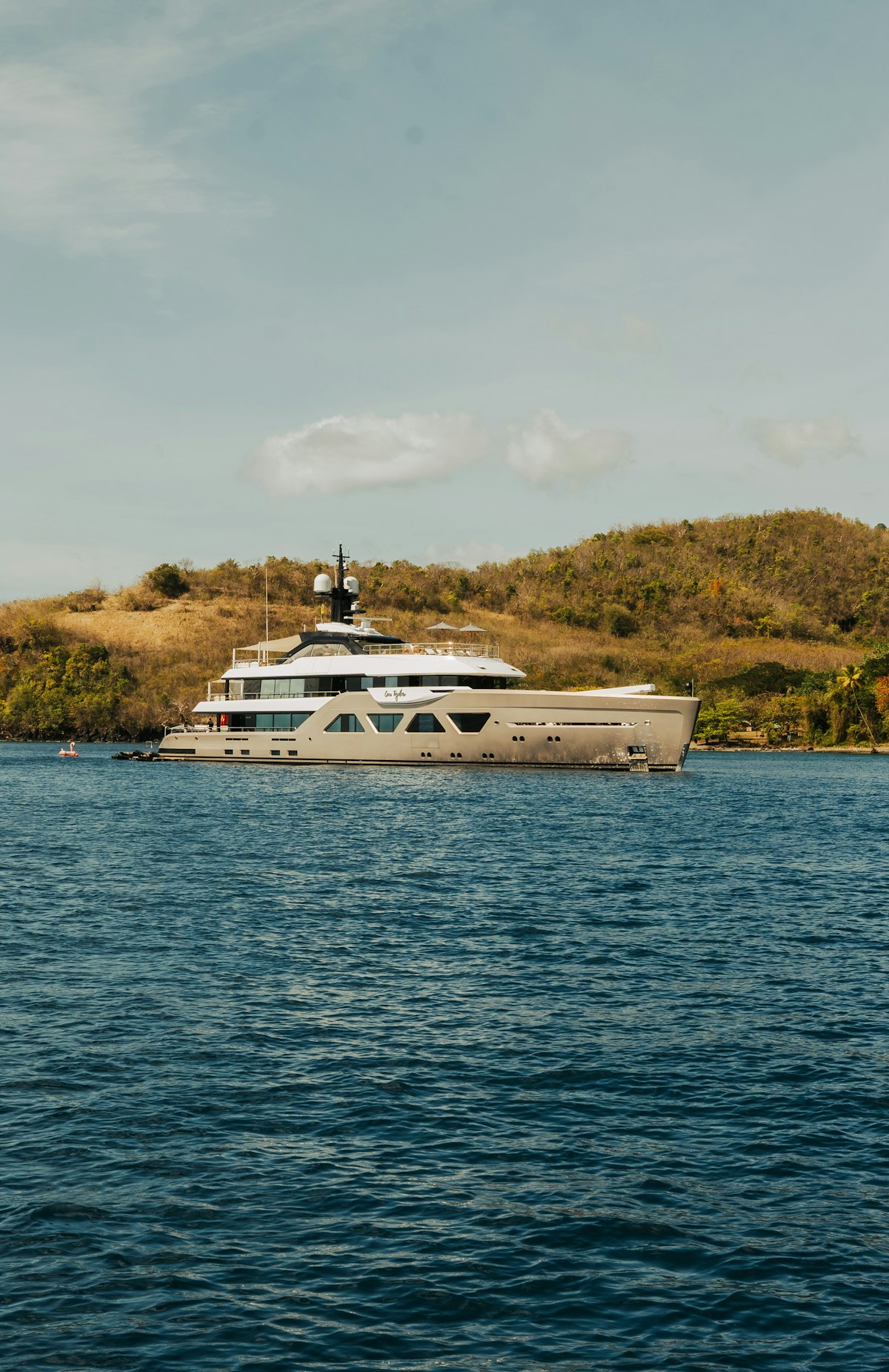A yacht at anchor near a quiet shoreline